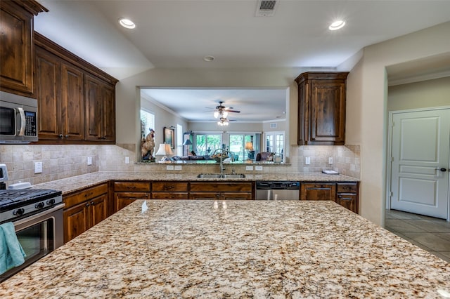 1628 Overwood Dr, Frisco, TX 75036 - kitchen with appliances with stainless steel finishes, a sink, a ceiling fan, recessed lighting, and ornamental molding