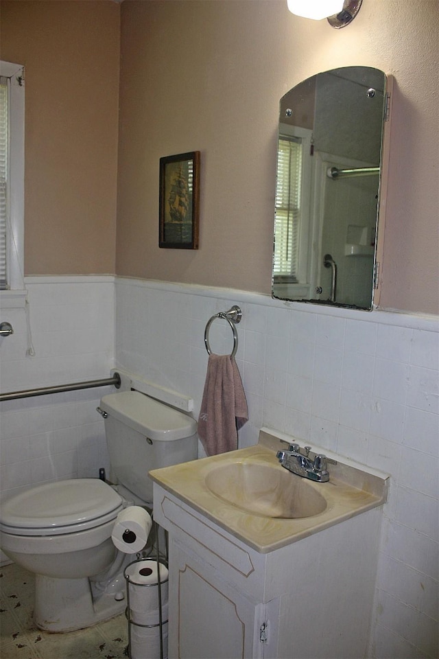 205 N Texas St, Whitney, TX 76692 - full bathroom featuring tile walls, a wainscoted wall, a shower with shower door, toilet, and vanity