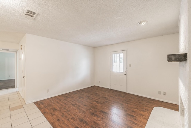 6188 Vega Dr, Fort Worth, TX 76133 - foyer with a textured ceiling, wood finished floors, and baseboards