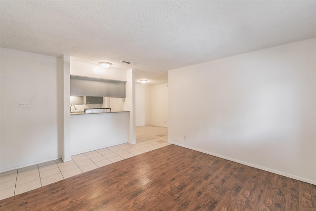 6188 Vega Dr, Fort Worth, TX 76133 - unfurnished living room with wood finished floors, baseboards, and a textured ceiling