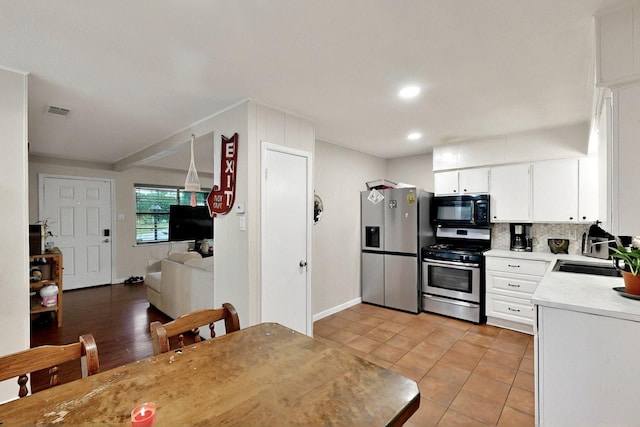 2422 Sue Cir, Mesquite, TX 75149 - kitchen featuring appliances with stainless steel finishes, light countertops, backsplash, white cabinets, and recessed lighting