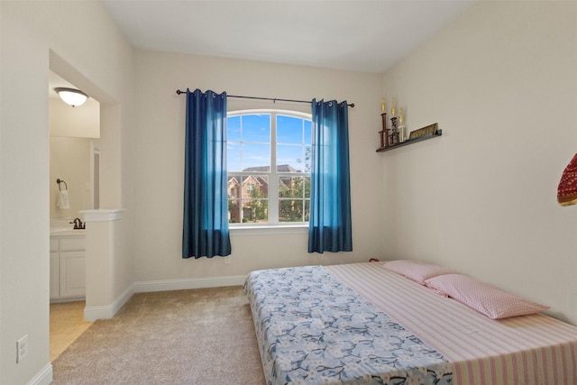 bedroom with carpet, a sink, and baseboards