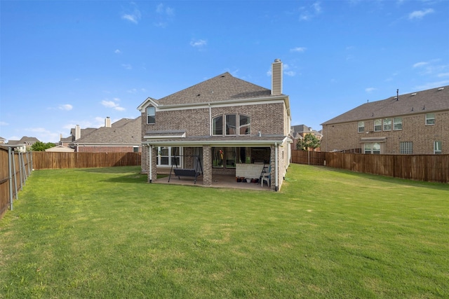 back of property featuring a chimney, brick siding, and a patio area