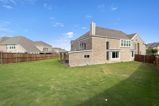 back of property with a chimney and brick siding