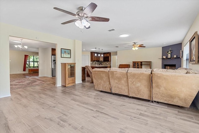 1717 Adams Ln, Azle, TX 76020 - living room featuring ceiling fan, a fireplace, light wood finished floors, and baseboards