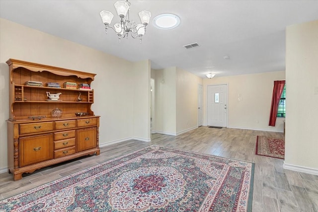 1717 Adams Ln, Azle, TX 76020 - entryway featuring a chandelier, light wood-style floors, and baseboards
