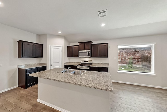 4612 Corktree Ln, Fort Worth, TX 76036 - kitchen featuring stainless steel appliances, a sink, light wood-style floors, baseboards, and dark brown cabinetry