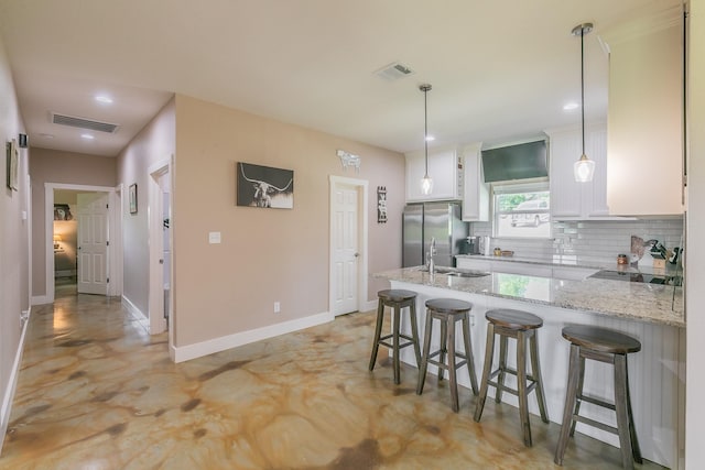 505 Advance Rd, Weatherford, TX 76088 - kitchen featuring freestanding refrigerator, backsplash, a peninsula, a kitchen breakfast bar, and white cabinetry