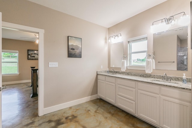 505 Advance Rd, Weatherford, TX 76088 - bathroom featuring finished concrete flooring, double vanity, and baseboards