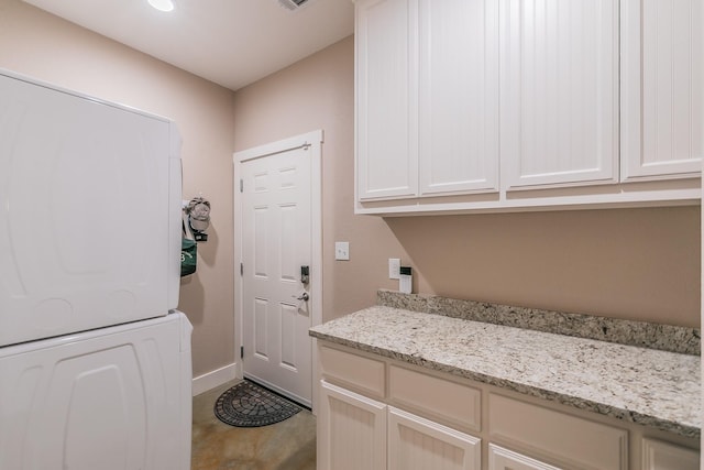 505 Advance Rd, Weatherford, TX 76088 - washroom with estacked washer and dryer, cabinet space, and baseboards