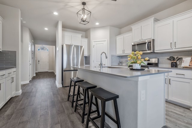 15720 Redgrave Dr, Fort Worth, TX 76247 - kitchen featuring appliances with stainless steel finishes, a sink, tasteful backsplash, a kitchen bar, and an island with sink
