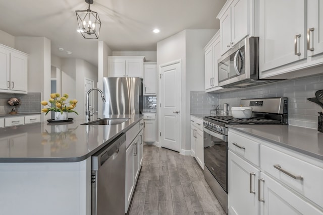 15720 Redgrave Dr, Fort Worth, TX 76247 - kitchen with appliances with stainless steel finishes, a sink, light wood finished floors, tasteful backsplash, and recessed lighting