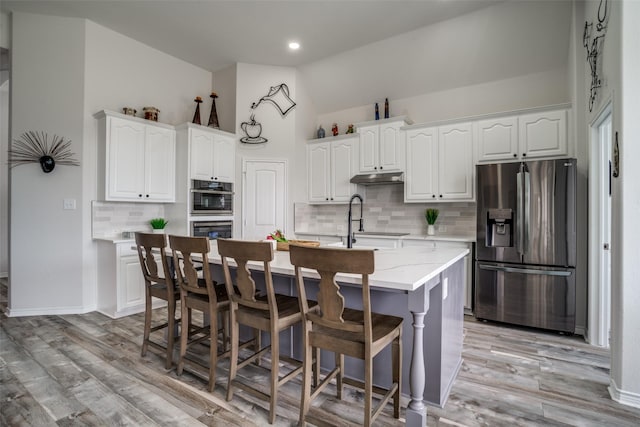 1312 Merrimac Dr, Allen, TX 75002 - kitchen featuring stainless steel fridge, vaulted ceiling, under cabinet range hood, decorative backsplash, and white cabinetry
