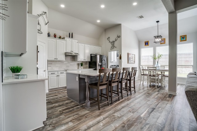 1312 Merrimac Dr, Allen, TX 75002 - kitchen featuring stainless steel refrigerator with ice dispenser, wood finished floors, white cabinets, backsplash, and a breakfast bar area