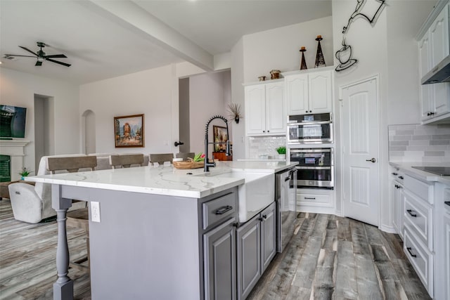 1312 Merrimac Dr, Allen, TX 75002 - kitchen featuring a sink, gray cabinetry, stainless steel dishwasher, a kitchen breakfast bar, and wood finished floors