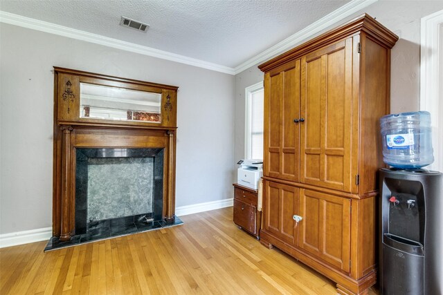 5202 Morningside Ave, Dallas, TX 75206 - detailed view of wood finished floors, a fireplace with raised hearth, baseboards, crown molding, and a textured ceiling