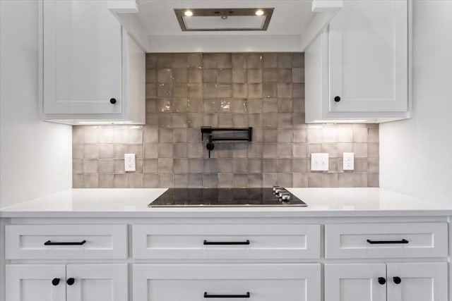 10201 Castleberry Ln, Waco, TX 76712 - kitchen with black electric stovetop, white cabinetry, and light countertops
