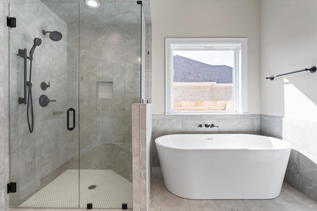 10201 Castleberry Ln, Waco, TX 76712 - full bathroom featuring a stall shower, a freestanding tub, tile walls, and wainscoting