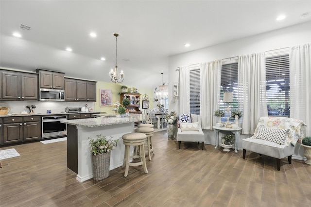 1440 Glade Meadows Dr, Burleson, TX 76058 - kitchen with stainless steel appliances, a chandelier, a kitchen breakfast bar, dark wood finished floors, and recessed lighting