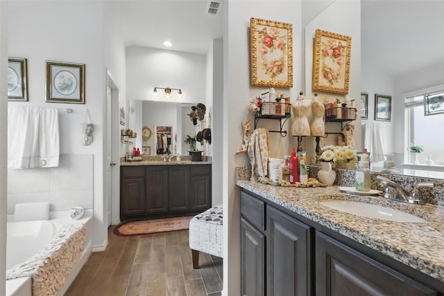 1440 Glade Meadows Dr, Burleson, TX 76058 - bathroom with wood finished floors, two vanities, and a tub