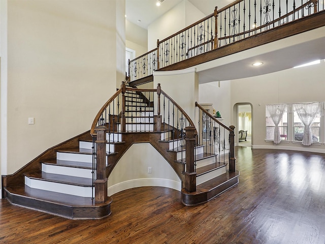 2165 Hidalgo Ln, Frisco, TX 75034 - stairs featuring a towering ceiling, arched walkways, wood finished floors, baseboards, and recessed lighting
