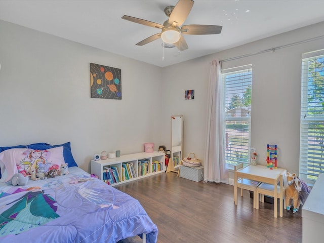 bedroom featuring multiple windows, wood finished floors, and a ceiling fan