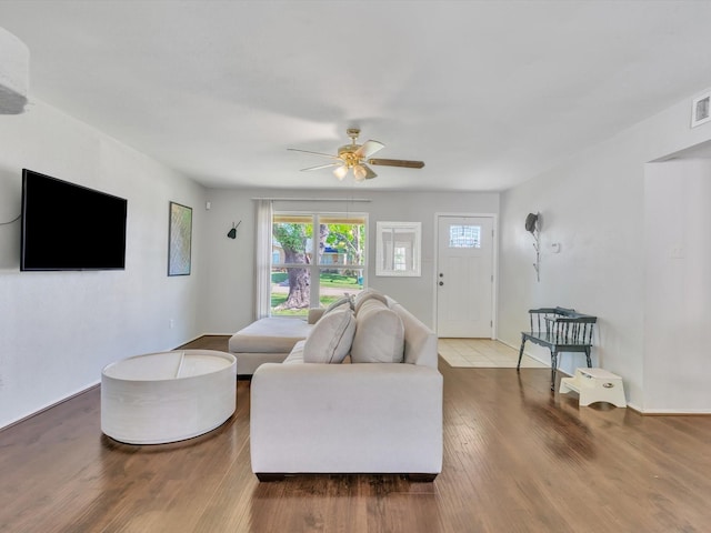 living area with plenty of natural light, ceiling fan, and wood finished floors