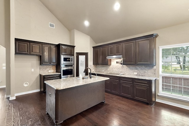 kitchen featuring appliances with stainless steel finishes, dark wood-style floors, a sink, dark brown cabinetry, and backsplash