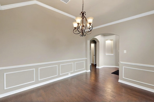 unfurnished room with arched walkways, a chandelier, wood finished floors, ornamental molding, and a decorative wall