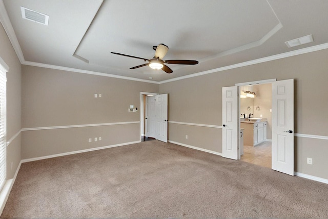 unfurnished bedroom featuring light carpet, baseboards, a sink, crown molding, and a ceiling fan