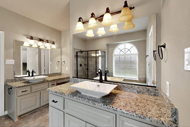 bathroom with a shower stall, two vanities, and tile patterned flooring