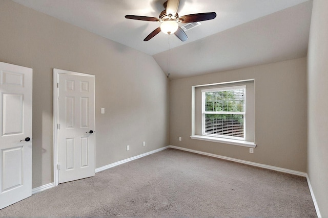 spare room with carpet floors, a ceiling fan, baseboards, and vaulted ceiling