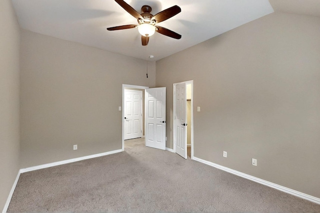 empty room with carpet flooring, a ceiling fan, baseboards, and lofted ceiling
