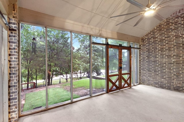 unfurnished sunroom featuring lofted ceiling, french doors, and a barn door