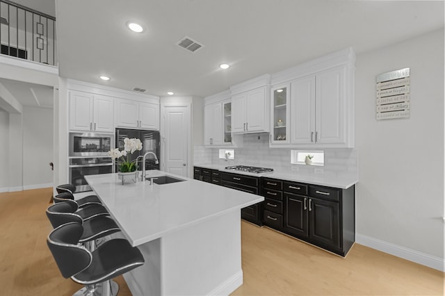 10969 Coastal Violet Rd, Frisco, TX 75035 - kitchen with appliances with stainless steel finishes, a sink, dark cabinetry, white cabinets, and a breakfast bar