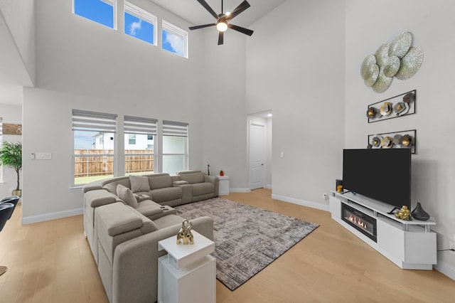 10969 Coastal Violet Rd, Frisco, TX 75035 - living room featuring a ceiling fan, a high ceiling, wood finished floors, and baseboards