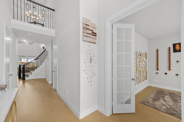 10969 Coastal Violet Rd, Frisco, TX 75035 - entryway featuring stairway, light wood-style floors, a chandelier, baseboards, and a towering ceiling