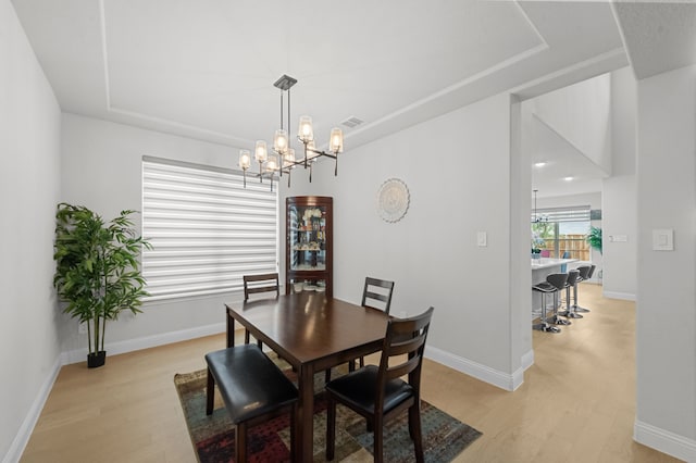 10969 Coastal Violet Rd, Frisco, TX 75035 - dining area featuring light wood-type flooring, a chandelier, baseboards, and a raised ceiling