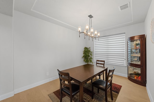 10969 Coastal Violet Rd, Frisco, TX 75035 - dining area with light wood-style flooring, baseboards, a chandelier, and a raised ceiling