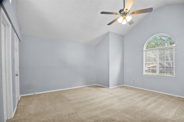 unfurnished bedroom featuring lofted ceiling, carpet floors, baseboards, a textured ceiling, and ceiling fan