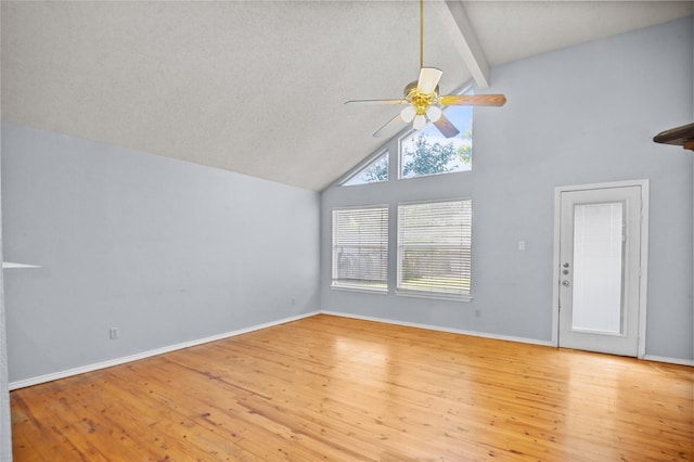 unfurnished living room with ceiling fan, high vaulted ceiling, wood finished floors, beam ceiling, and baseboards