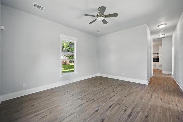 unfurnished room featuring wood finished floors, a ceiling fan, and baseboards