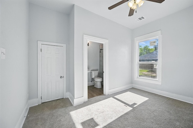unfurnished bedroom featuring carpet floors, baseboards, connected bathroom, and ceiling fan