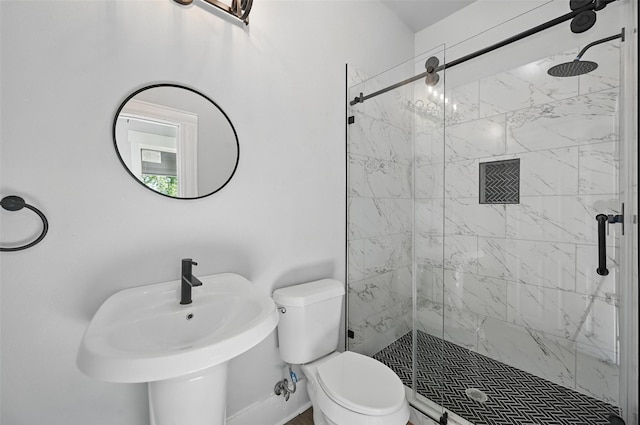 bathroom with toilet, a marble finish shower, and a sink