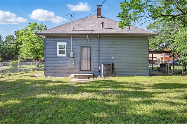 rear view of property featuring central AC unit, a shingled roof, and a chimney