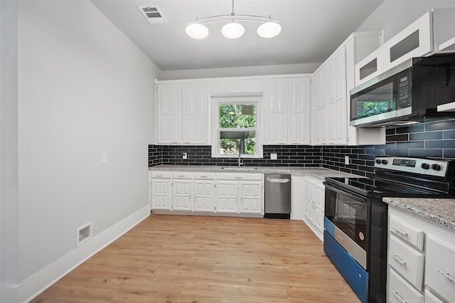 kitchen with appliances with stainless steel finishes, white cabinets, decorative backsplash, light wood-type flooring, and a sink