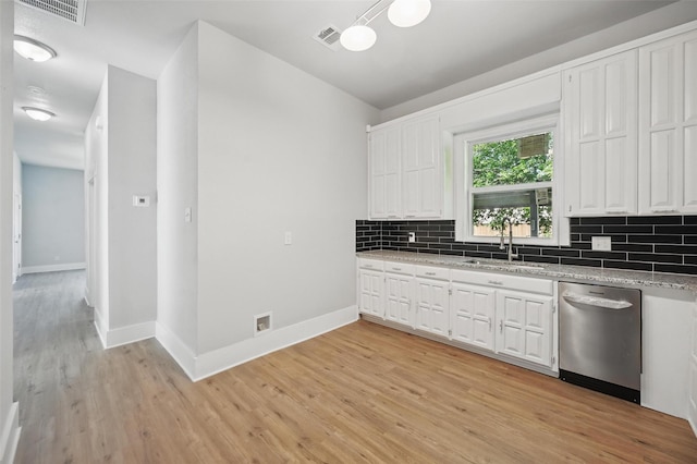 kitchen featuring stainless steel dishwasher, a sink, light wood-style flooring, backsplash, and vaulted ceiling
