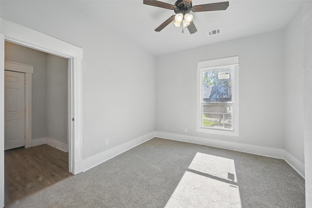 unfurnished room with carpet floors, a ceiling fan, and baseboards