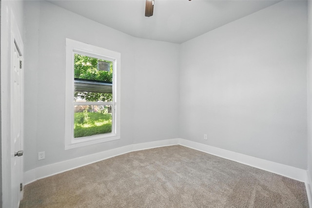 carpeted empty room featuring ceiling fan and baseboards