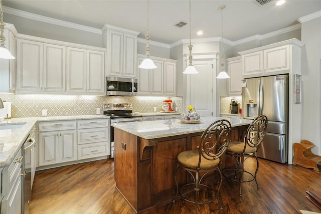517 Hearth Ter, Argyle, TX 76226 - kitchen with appliances with stainless steel finishes, dark wood-style flooring, a center island, light stone countertops, and recessed lighting